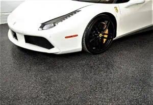White sports car on a black and gray full flake epoxy polyaspartic coated floor.